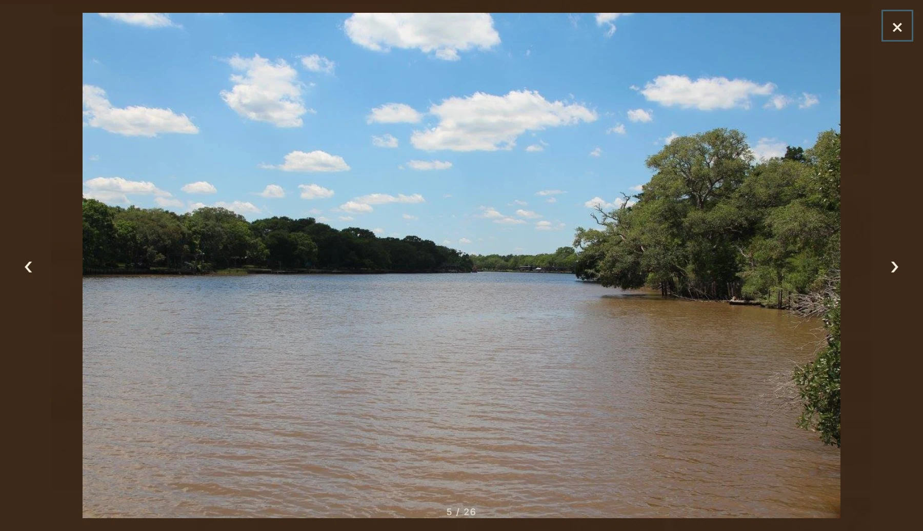 The gallery lightbox open over a river photo, using the native HTML dialog element with left and right arrow navigation and a 5 of 26 photo counter.